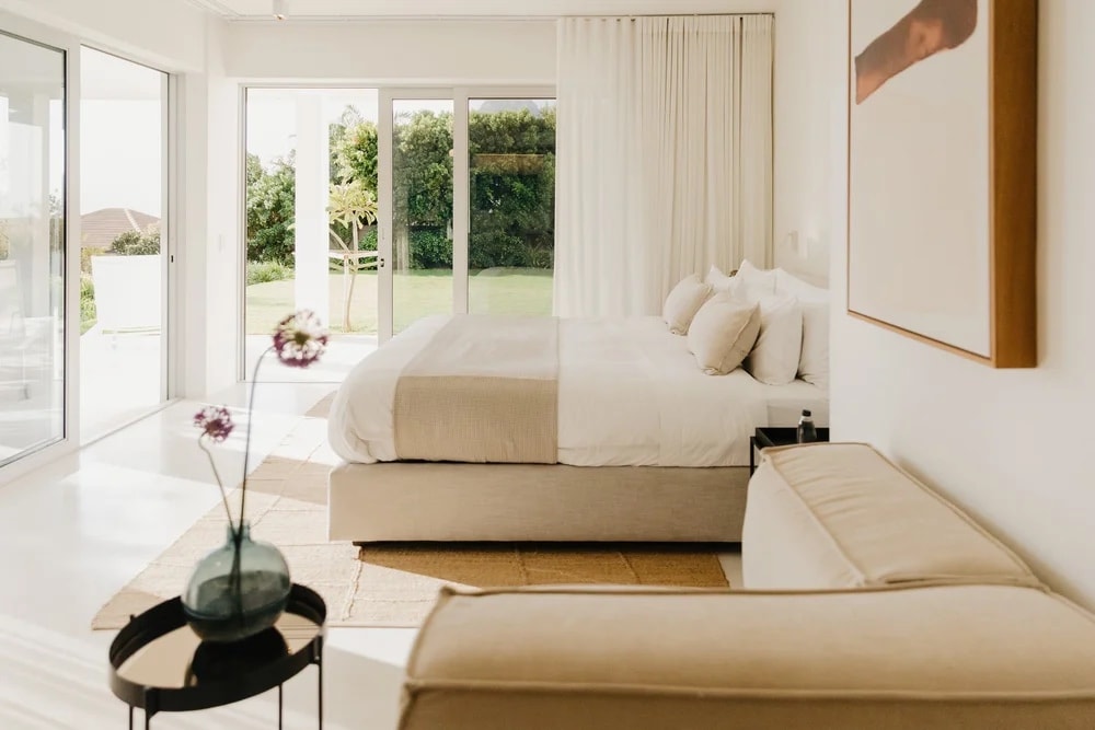 A bedroom opening onto the garden, the doors pushed back